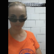 An attractive blonde girl wearing sunglasses and an orange shirt records herself taking a piss and a shit into a public toilet and then wiping herself. No product shown. Vertical format video. About 3.5 minutes.